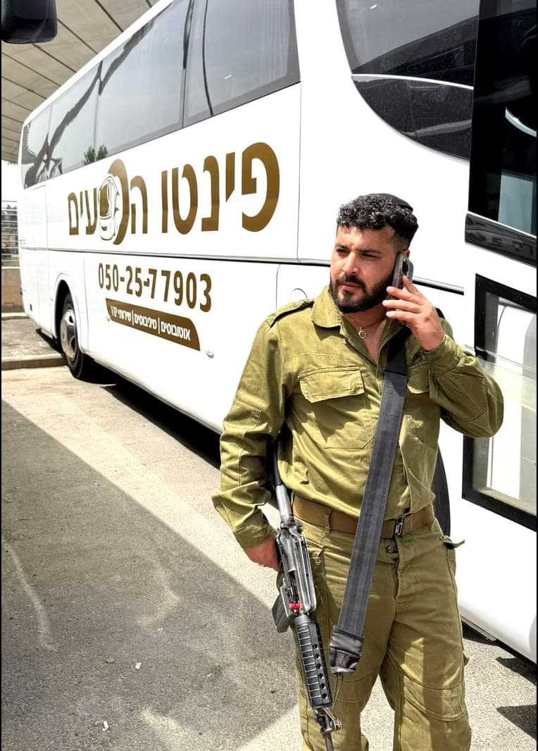 חייל לצד אוטובוס של פינטו הסעים